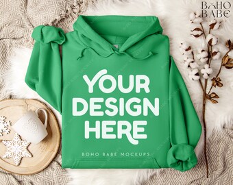 May include: A green hooded sweatshirt with the text "YOUR DESIGN HERE" and "BOHO BABE MOCKUPS" printed on the front.
