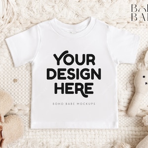 May include: White baby onesie with the text "YOUR DESIGN HERE" and "BOHO BABE MOCKUPS" on a white fuzzy background.