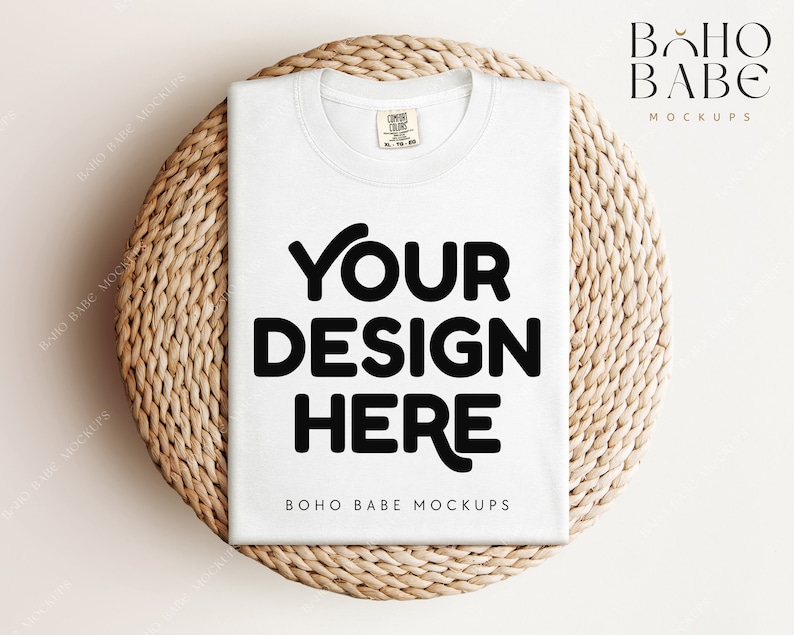 May include: White t-shirt mockup on a woven round mat. The t-shirt has the text "YOUR DESIGN HERE" printed on the front.