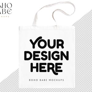 May include: A white tote bag with the text "YOUR DESIGN HERE" in bold black letters. The bag has a simple design with a rectangular shape and white handles. The words "BOHO BABE MOCKUPS" are at the top left and bottom of the bag.