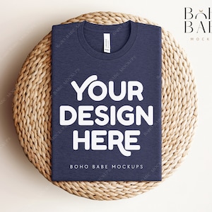 May include: A navy blue t-shirt mockup with the text "YOUR DESIGN HERE" in white on a woven straw mat. The text "BOHO BABE MOCKUPS" is also visible on the shirt.