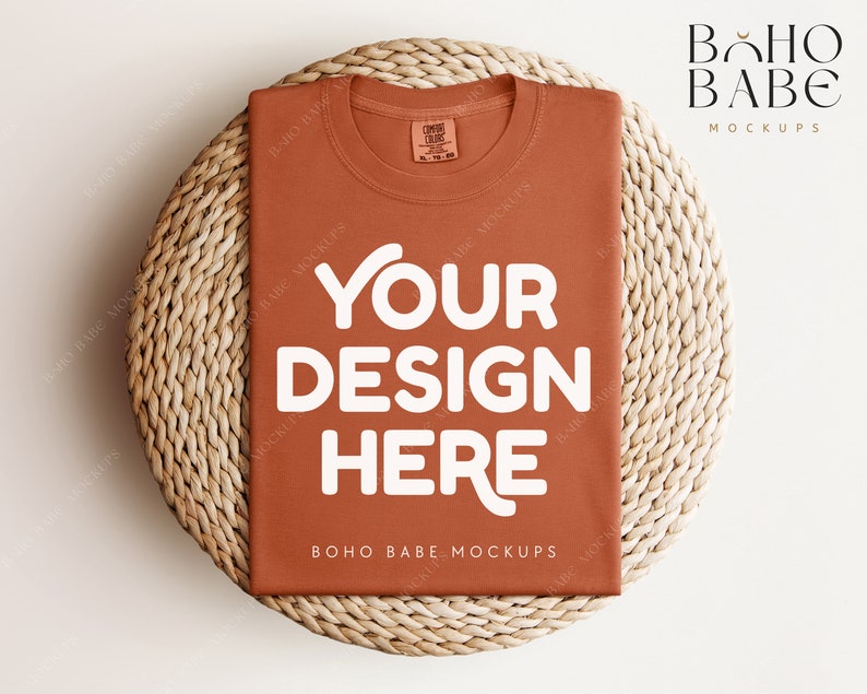 May include: A rust-colored t-shirt mockup with the text "YOUR DESIGN HERE" in white on a woven straw mat. The text "BOHO BABE MOCKUPS" is also visible on the t-shirt.
