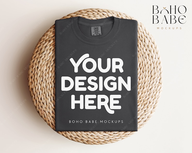 May include: A dark gray t-shirt with the text "YOUR DESIGN HERE" in white on a woven wicker surface. The text "BOHO BABE MOCKUPS" is also visible on the shirt.