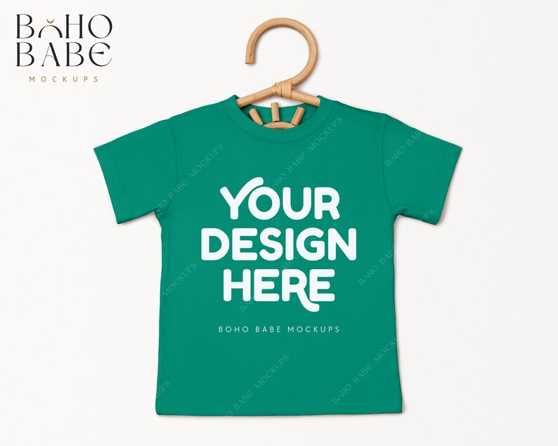 May include: A green t-shirt mockup with a hanger. The shirt has the text "YOUR DESIGN HERE" and "BOHO BABE MOCKUPS" printed on it.
