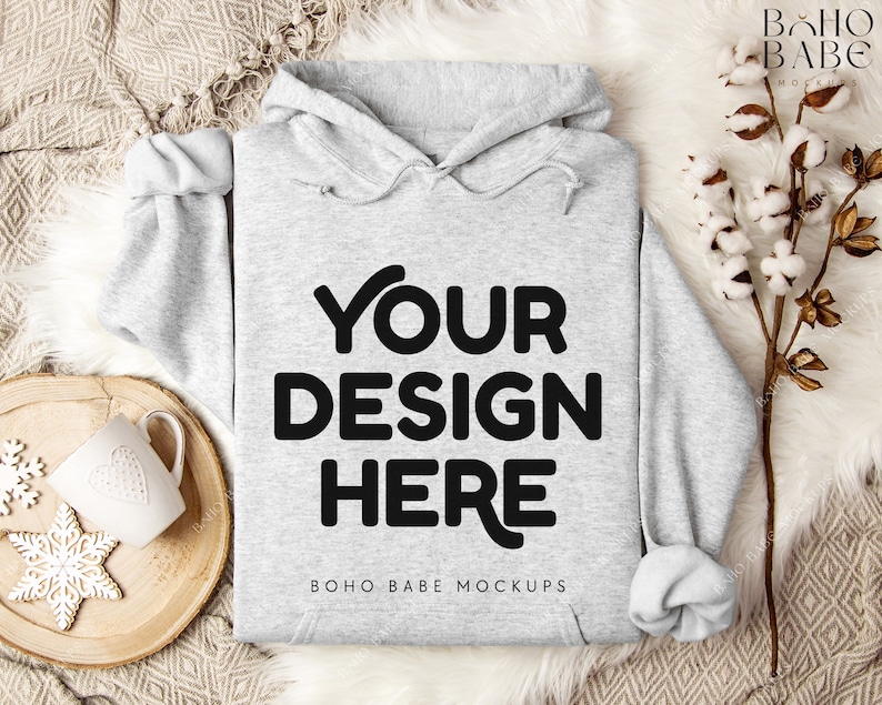 Puede incluir: Una sudadera con capucha gris con el texto "YOUR DESIGN HERE" y "BOHO BABE MOCKUPS" impreso en la parte delantera.