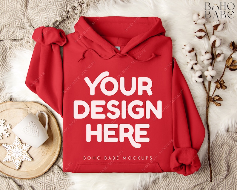 Puede incluir: Maqueta de sudadera con capucha roja con el texto "Your Design Here" sobre un fondo blanco peludo.