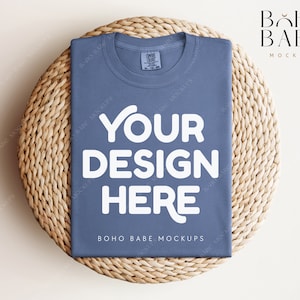 May include: A blue t-shirt mockup with the text "YOUR DESIGN HERE" on a woven straw mat. The text "BOHO BABE MOCKUPS" is also visible on the shirt.