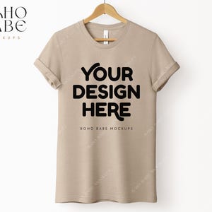 May include: A beige t-shirt mockup with the text "YOUR DESIGN HERE" and "BOHO BABE MOCKUPS" printed on the front.