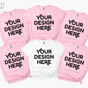 May include: Six t-shirts, three pink and three white, laid out on a white background. Each t-shirt has the text "YOUR DESIGN HERE" printed in black on the front.
