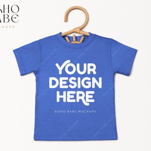 May include: A blue t-shirt mockup with the text "YOUR DESIGN HERE" and "BOHO BABE MOCKUPS" printed on the front.