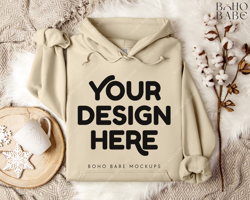 Puede incluir: Una sudadera con capucha beige con capucha y cord&oacute;n. La sudadera tiene el texto "YOUR DESIGN HERE" y "BOHO BABE MOCKUPS" impreso en la parte delantera.
