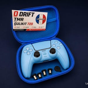 Peut inclure: Une manette de jeu bleu clair avec des détails noirs, accompagnée d'un ensemble d'embouts noirs, présentée dans un étui bleu. L'étui contient également une carte d'information produit avec le texte "DRIFT TMR GULIKIT 720".