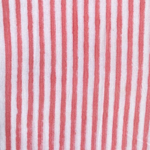 以下が含まれることがあります： 垂直ストライプの生地のクローズアップ。ストライプは、ソフトコーラル色と白の間で交互に表示されます。生地は、わずかにテクスチャ加工された表面を持つ、軽量の素材（おそらく綿またはリネン）のようです。