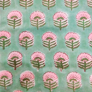 Puede incluir: Un patrón repetido de diseños florales rosas con tallos y hojas verdes sobre un fondo verde claro. Las flores tienen un diseño de pétalos detallado y en capas. La tela tiene una apariencia ligeramente texturizada.