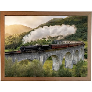 Può includere: Un treno a vapore rosso e nero viaggia su un ponte di pietra con più archi. Il treno è circondato da colline verdi e nuvole bianche.