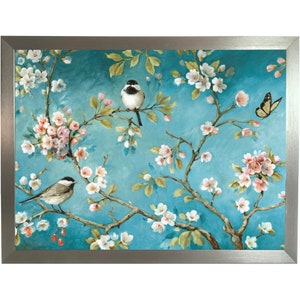 May include: A framed painting of a blue sky with white and pink blossoms on branches. Two small black and white birds are perched on the branches, and a butterfly is flying in the upper right corner.