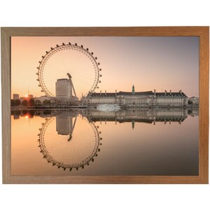 Peut inclure: Impression encadrée du London Eye au lever du soleil. L'image montre la grande roue se reflétant dans l'eau, avec une lumière dorée. Le cadre est de couleur marron clair. Les bâtiments sont également reflétés.
