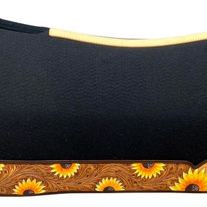May include: Black saddle pad with a tan leather trim and sunflower design. The pad has a brown leather border with a sunflower pattern and the word "MAVERICK" in white.
