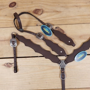 Puede incluir: Un petral de caballo de cuero marr&oacute;n con hebillas plateadas y detalles decorativos. El petral tiene un dise&ntilde;o de borde festoneado e incluye un cabezal a juego. La etiqueta dice "Housh".