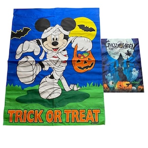 May include: Two Halloween-themed flags. One features Mickey Mouse as a mummy holding a jack-o'-lantern treat bag, with the words "Trick or Treat." The other flag has a spooky scene with a black cat, pumpkins, and ghosts.