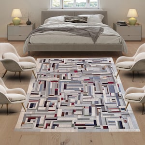 May include: A white, gray, and red geometric patterned rug with four white chairs in a living room setting.