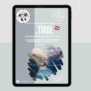 Könnte beinhalten: Ein digitales Tablet zeigt das Cover eines Wanderführers in den österreichischen Alpen. Das Cover zeigt ein Foto eines Paares, das auf einer Hängebrücke wandert, mit einem See und Bergen im Hintergrund. Der Titel des Buches lautet "Mein Wanderguide Bergwandern mit Hund" und der Untertitel lautet "Wandern mit Hund in Tirol".