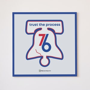 May include: A blue and red graphic of the Liberty Bell with the number 76 inside. The text "trust the process" is above the bell. The text "Philly Town Design & Co." is below the bell.