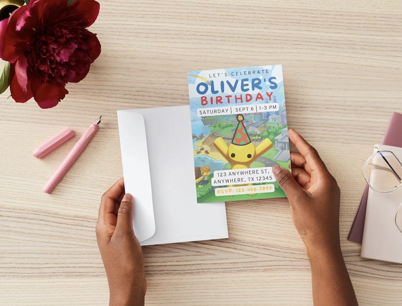 Op de afbeelding: Een verjaardagsuitnodiging met de tekst "LET'S CELEBRATE OLIVER'S BIRTHDAY" en evenementdetails. De uitnodiging toont een cartoonfiguur en wordt vastgehouden met een witte envelop. Een bordeauxrode bloem en roze pen liggen op het houten oppervlak.