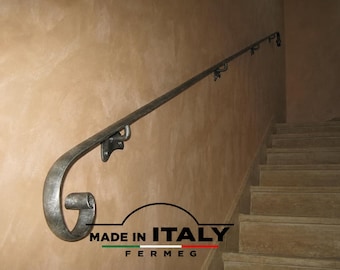 May include: A hand-forged metal handrail with a textured silver-grey finish and a decorative scrolled end. The rail is mounted to a wall with metal brackets and features the text MADE IN ITALY FERMEG with a small Italian flag graphic below.