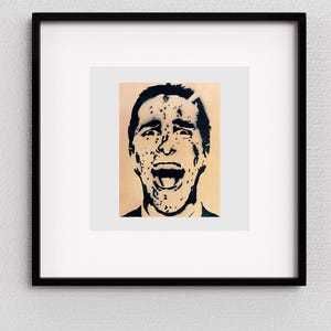Könnte beinhalten: Schwarz gerahmter Kunstdruck mit einem Schablonenporträt einer Person mit offenem Mund und angespannter Miene. Das Kunstwerk ist in Schwarzweiß gehalten, mit einem beigefarbenen Hintergrund.