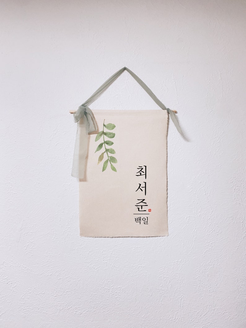 May include: A beige canvas wall hanging with a green watercolor leaf design and Korean text that reads "최선을 다할" which translates to "Do your best".