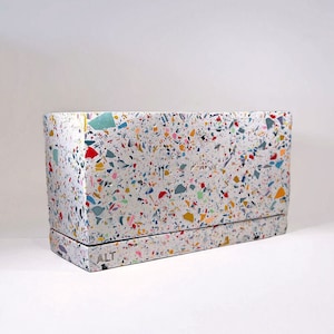 May include: A rectangular terrazzo planter with a white base and colourful flecks of blue, green, red, yellow, and pink. The planter has the word "ALT" inscribed on the front.