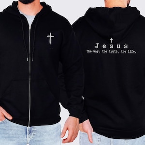 May include: Black zippered hoodie with a white cross on the left side and the text "Jesus the way. the truth. the life." on the right side.