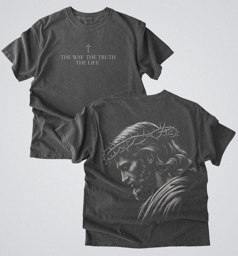 Puede incluir: Camiseta gris oscuro con el texto "THE WAY THE TRUTH THE LIFE" y una cruz. La parte trasera de la camiseta muestra una ilustraci&oacute;n detallada de una persona con una corona de espinas. La camiseta est&aacute; hecha de un material suave y c&oacute;modo.