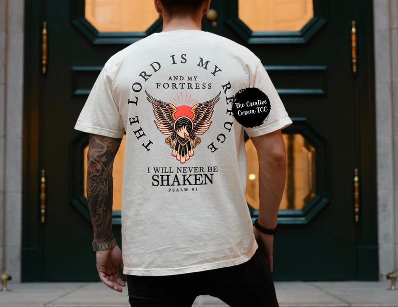 May include: A cream colored t-shirt with a graphic of an eagle with the text "The Lord is my refuge and my fortress. I will never be shaken. Psalm 91" printed on the back.