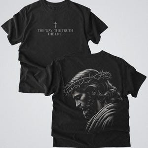 Puede incluir: Camisetas negras con gr&aacute;ficos religiosos. Una camiseta presenta una cruz y el texto "THE WAY, THE TRUTH, THE LIFE". La otra muestra una ilustraci&oacute;n detallada de un hombre con una corona de espinas.