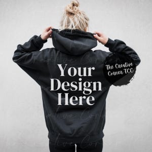 Könnte beinhalten: Schwarzer Kapuzenpullover mit dem Text "Your Design Here" auf der Rückseite. The Creative Corner TCC steht in einem Kreis auf der rechten Seite des Pullovers.