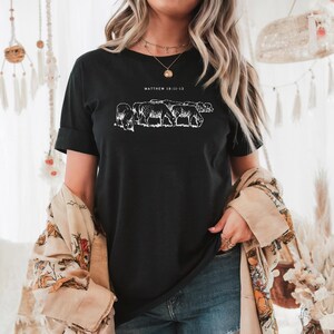 May include: Black t-shirt with a white graphic of a flock of sheep and the text "MATTHEW 18:11-13".