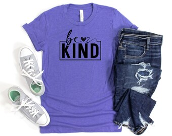 May include: Purple t-shirt with the text "be kind" in a black box with a small heart above the word "be".