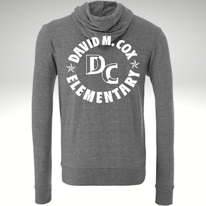 May include: Gray hooded sweatshirt with a white circle logo that says "David M. Cox Elementary" with the letters "DC" in the center.