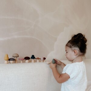 Toddler practicing hand coordination with Montessori mushroom toy