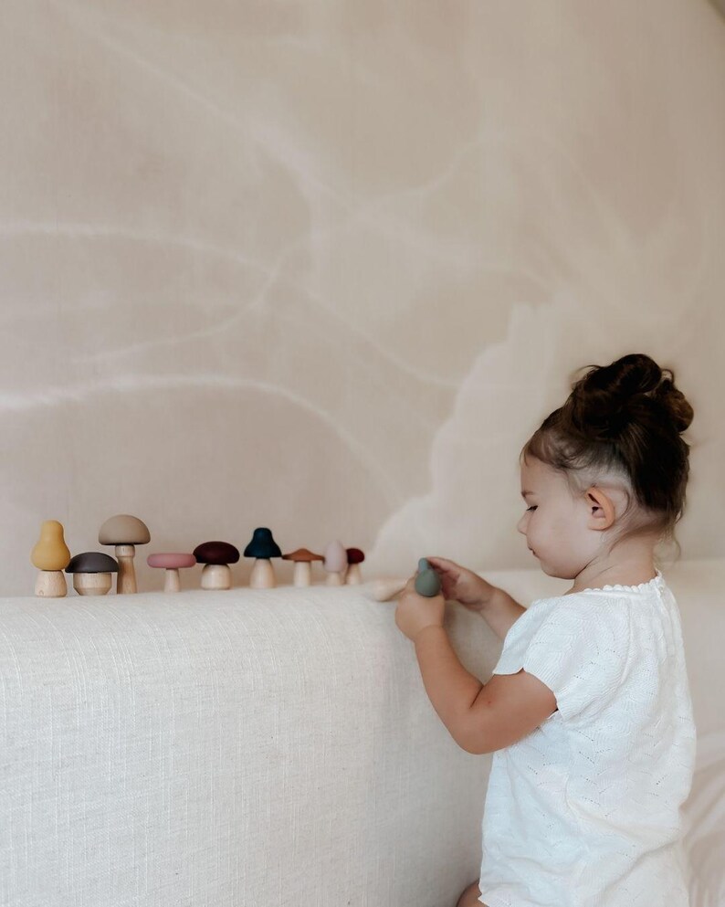 Toddler practicing hand coordination with Montessori mushroom toy