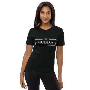 May include: Black t-shirt with white text that reads "Real MUDDA" in a rectangular frame.