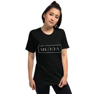 May include: Black t-shirt with white text that reads "Sing like a MUDDA" in a rectangle.