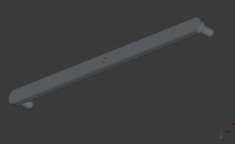 Peut inclure: Une poign&eacute;e rectangulaire grise avec des extr&eacute;mit&eacute;s arrondies et une petite indentation circulaire. La poign&eacute;e a une projection cylindrique &agrave; chaque extr&eacute;mit&eacute;. L'objet est pos&eacute; sur un fond gris fonc&eacute;.