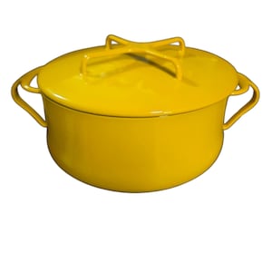 May include: A bright yellow enameled metal cooking pot with a matching lid. The pot features two curved side handles and a distinctive cross-shaped handle on top of the lid. The surface has a smooth, glossy finish throughout the entire exterior.
