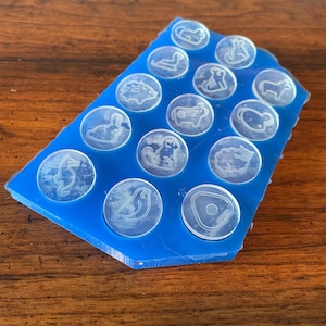 May include: Blue silicone mold with 15 clear resin blanks, each featuring a different animal design. The designs include a cat, a bird, a rabbit, a cow, a fish, a hedgehog, a monkey, a dog, a turtle, a deer, a bear, a sheep, a pig, a horse, and a goose.