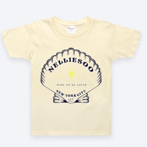 May include: Cream-colored t-shirt featuring a navy blue seashell design with the text "NELLIESOO" and "MADE TO BE LOVED" and "NEW YORK CITY LST 2023". The design includes a yellow star.