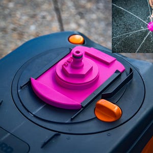 Peut inclure: Gros plan sur un composant de système d'eau bleu foncé et rose avec des accents orange. La section rose a une buse et est entourée d'une base bleu foncé. Un encart montre un arroseur rose en cours d'utilisation.