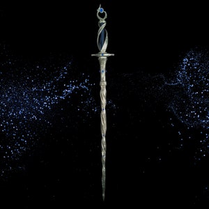 May include: A silver and blue decorative sword with a twisted blade and blue gemstone accents. The sword is set against a black background with a scattering of blue glitter.
